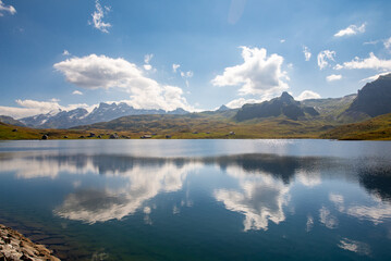 Clouds are reflected in the clear water of a mountain lake. Melchsee-Frutt near Lucerne, Switzerland in the Swiss Alps. Idylic Lake Landscape in summer.