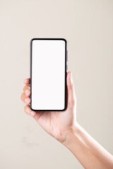 White screen phone in hand on grey background