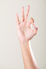 Female hand like gesture on grey background