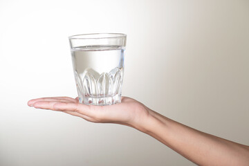 Water glass on palm on white background