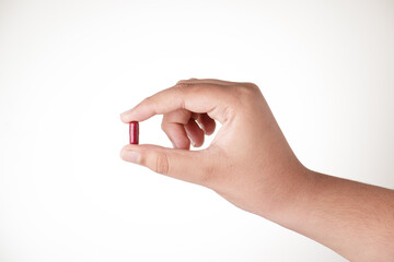 Capsule in hand on white background