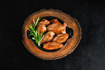 Chicken wings fried until half cooked, semi-finished product.Semi-finished chicken wings on a dark background.Half-finished. Quick cooking at home.Fast food.Semi-finished chicken wings lightly fried