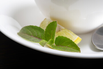 Closeup of tulsi leaf with lemon on plate