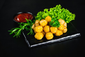 Chicken Breaded Raw Meat.Fast food.Fast cooking.Chicken nuggets with salad.Semifinished Breaded chicken nuggets from chicken fillet on a dark background with fresh herbs. Quick cooking at home.