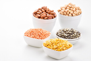 Raw lentils and gram in bowl on white background