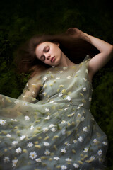 redhead woman sleeping in the forest, her dress is made of daisy flowers, fantasy dream concept