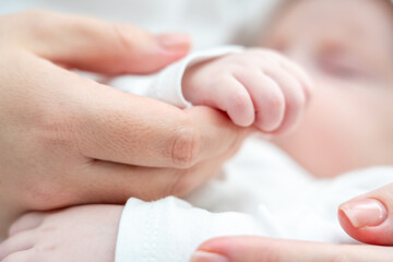 Serenity and love reflected in newborn's touch. Concept of the unspoken bond between mother and baby
