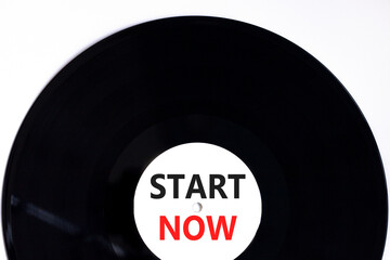 Start now symbol. Concept words Start now on beautiful black old retro vinyl disc. Beautiful white table white background. Business marketing, motivational start now concept. Copy space.