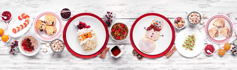 Christmas breakfast table scene. Overhead view on a white wood banner background. Fun holiday food...