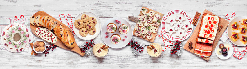 Christmas food table scene. Top down view on a white wood banner background. Selection of...