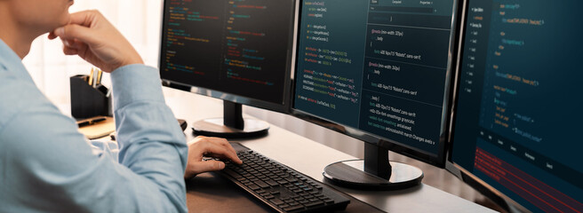 Software engineer working on application development on his computer display code and script on...