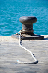 Marine port bollard with rope tied around it