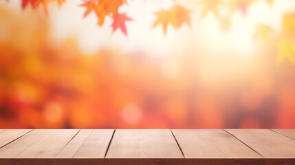 A wooden table stands out against a hazy Fall backdrop of red-yellow foliage. - obrazy, fototapety, plakaty
