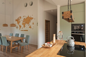 Interior of stylish kitchen with induction hob on the wooden counter on the island with modern lamp...