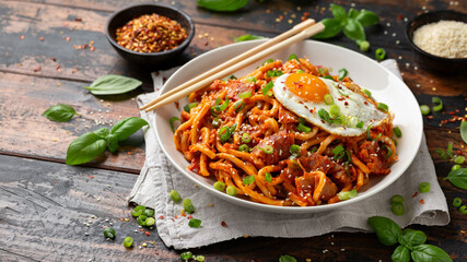 Kimchi Fried Udon Noodle with Fried Egg and bacon. Korean food.