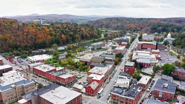 Aerial establishing shot of Montpelier, VT cityscape with forward camera rotation above State street towards Vermont State House.