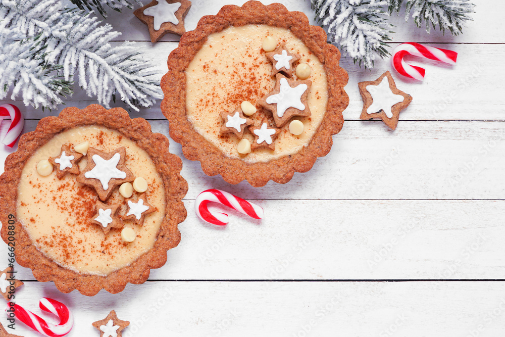 Poster christmas eggnog and gingerbread tarts. top down view table scene against a white wood background wi