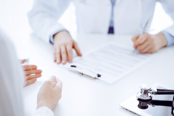 Stethoscope lying on the tablet computer in front of a doctor and patient sitting opposite each other at the background . Medicine, healthcare concept