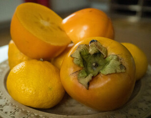 Naklejka na ściany i meble Sweet Persimmon, one of the delicious fruit types, with tangerines lying