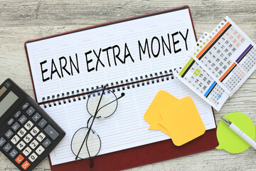 earning extra money, notepad with text near calculator and calendar . Concept of financial planning Make more extra money