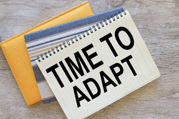 Time to Adapt. top view of a notepad with text. notepad with spring