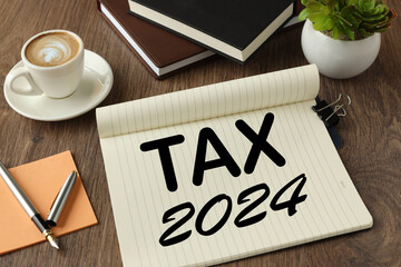 2024 taxes new year symbol. text on a notepad. pen on sticker.