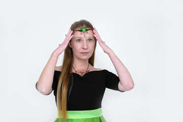 St.Patrick 's Day. Portrait of a girl in an elf costume for the holiday of St. Patrick's Day in green party decorations on a light background.