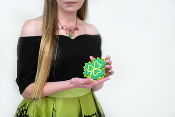 St.Patrick 's Day. A girl holds in her hands a handmade green clover leaf - a symbol of the Irish traditional holiday.