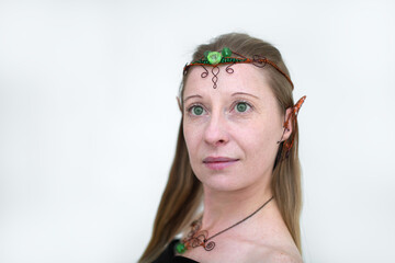 St.Patrick 's Day. Portrait of a girl in an elf costume for the holiday of St. Patrick's Day in green party decorations on a light background.