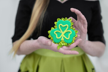 St.Patrick 's Day. A girl holds in her hands a handmade green clover leaf - a symbol of the Irish traditional holiday.