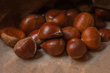 Sweet Chestnuts. Pile of ripe chestnuts on a rustic  background closeup.