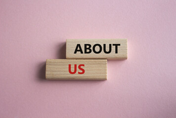 About us symbol. Concept word About us on wooden blocks. Beautiful pink background. Business and...