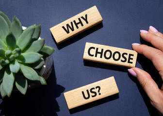 Why choose us symbol. Concept words Why choose us on wooden blocks. Beautiful deep blue background...