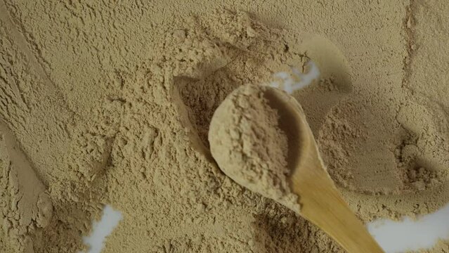 Maca powder on the table, top view. Maca gelatinized flour, close-up. Peruvian superfood, natural food supplement used for healthy drinks, cocktails and smoothies.  4K video.