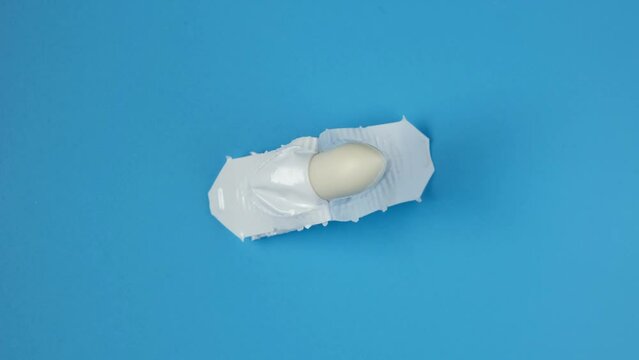 Rectal suppositories or candles in close-up on a blue background. Remedy for treatment of acute and chronic bacterial prostatitis. Video 4K, Rotating.