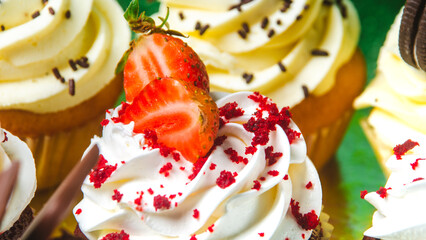 panecillos o cupcakes con crema y fresas decorados con chispitas