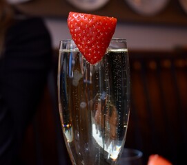 Strawberry attached to a glass of champagne