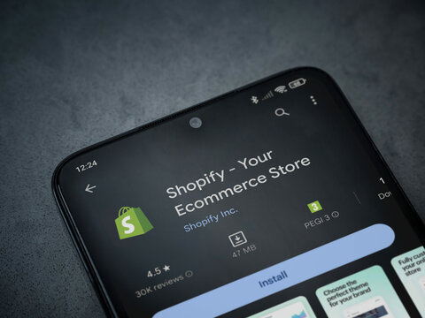 Shopify app play store page on smartphone on a dark marble stone background