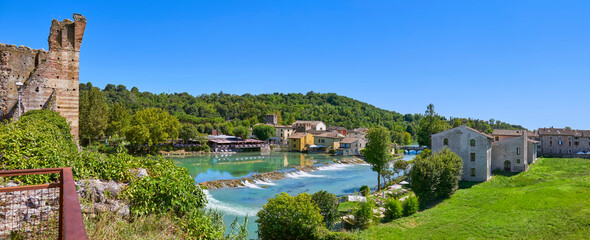 Fototapeta na wymiar Beautiful panoramic view from the medieval bridge over the Minico River to the mill village of Borghetto in the south of Lake Garda, in Veneto, Italy.