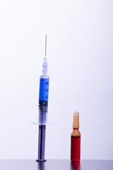 Injection and vial at table on grey background
