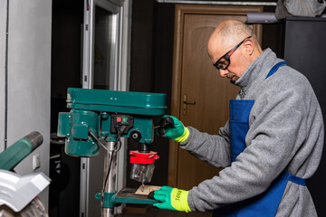 Working on vertical drilling machines in the industrial plant for producing new items