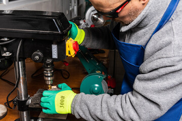 Working on vertical drilling machines in the industrial plant for producing new items