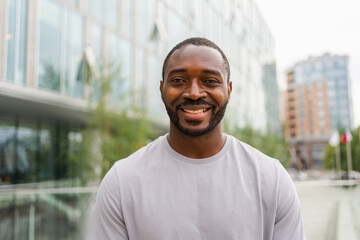 Happy african american man smiling outdoor. Portrait of young happy man on street in city. Cheerful joyful handsome person guy looking at camera. Freedom happiness carefree happy people concept - obrazy, fototapety, plakaty
