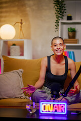 Caucasian bald woman recording a podcast while looking into the camera