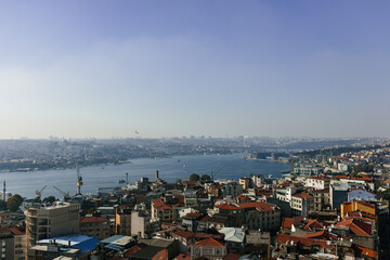 Naklejka na ściany i meble Beautiful landscape over city rooftops, bay and city in the background. View of the Bosphorus and Istanbul from the Galata Tower. Istanbul, Türkiye – October 15, 2023