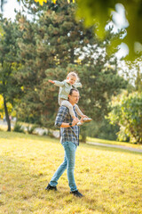 Fototapeta premium Young father and funny little daughter having fun together in autumn park of Prague, Europe