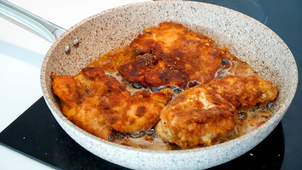 Big fried chicken pieces in a saucepan