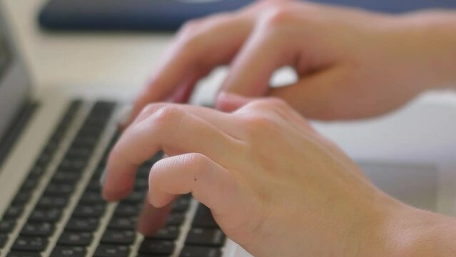 Hands typing on a laptop or computer keyboard to send emails and surf the web in the office