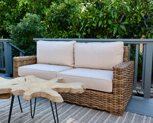 outdoor wicker sofa and teak side tables on the deck