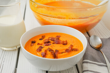 Roasted butternut squash soup served with a crispy bacon and heavy cream topping